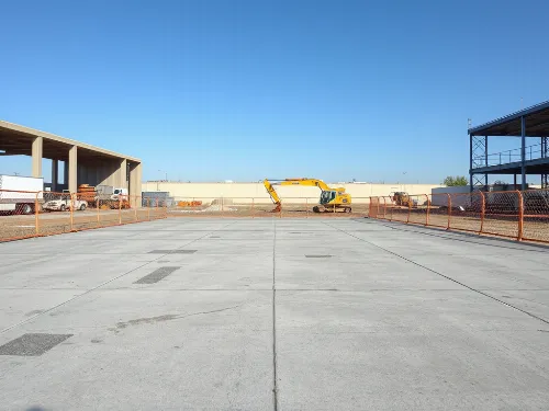 Large commercial concrete slab under construction with safety barriers